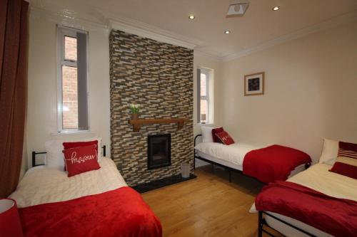 a room with two beds and a brick fireplace at St Ann's House in Rotherham
