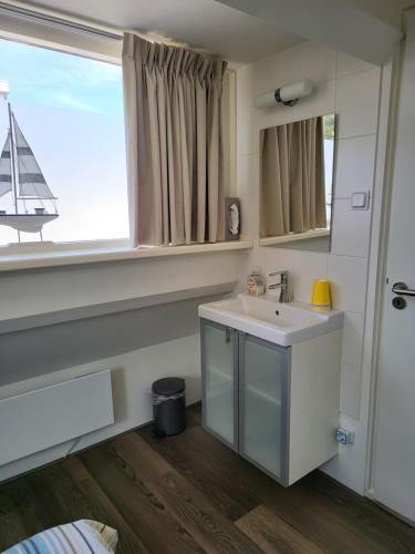 uma casa de banho com um lavatório e uma janela em FlipFlop em Noordwijk aan Zee