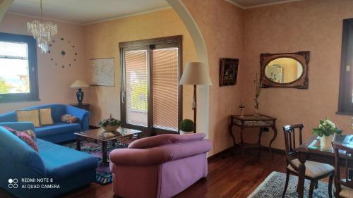 a living room with a blue couch and a table at B&B Golfo Asinara Suite & Relax in Sorso