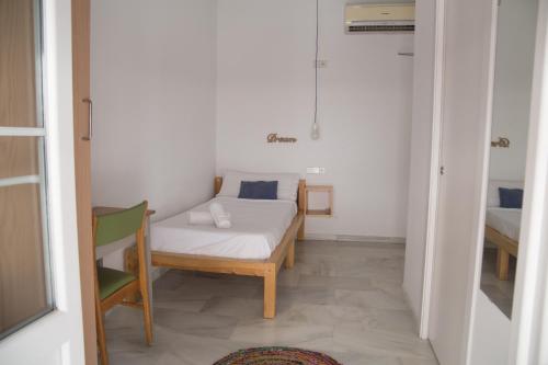 a small bedroom with a bed and a table at The Nomad Hostel&Pension in Seville