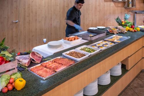 a buffet with meat and other food on a counter at Vilar Rural De Sant Hilari Sacalm by Serhs Hotels in Sant Hilari Sacalm