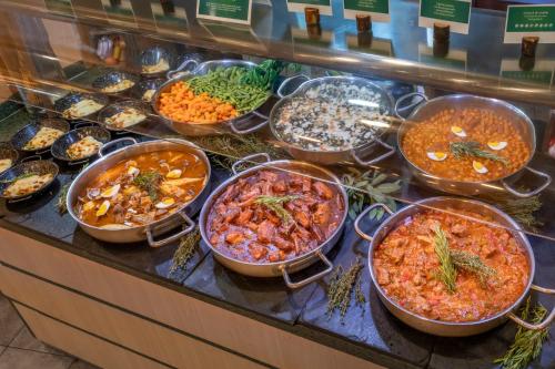a buffet filled with different types of food on a counter at Vilar Rural De Sant Hilari Sacalm by Serhs Hotels in Sant Hilari Sacalm