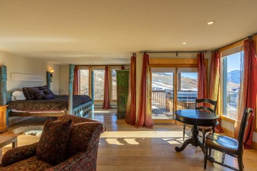 a bedroom with a bed and a balcony with mountains at Nordic Inn in Crested Butte