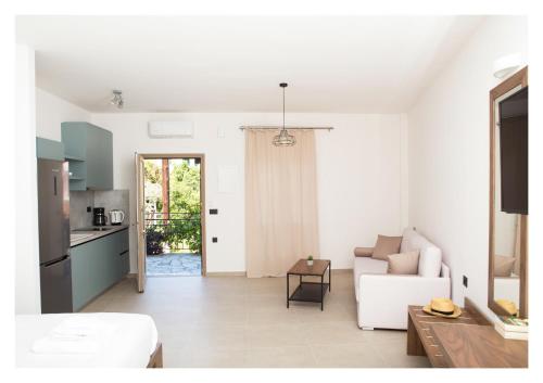 a white living room with a white couch and a kitchen at Le Quartier Comfy Studios in Parga