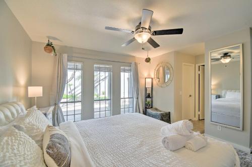 Schlafzimmer mit einem weißen Bett und einem Deckenventilator in der Unterkunft Sleek Phoenix Condo Walk to Biltmore Fashion Park in Phoenix