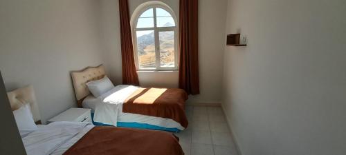 una piccola camera con due letti e una finestra di Nemrut Güneş Motel a Yandere