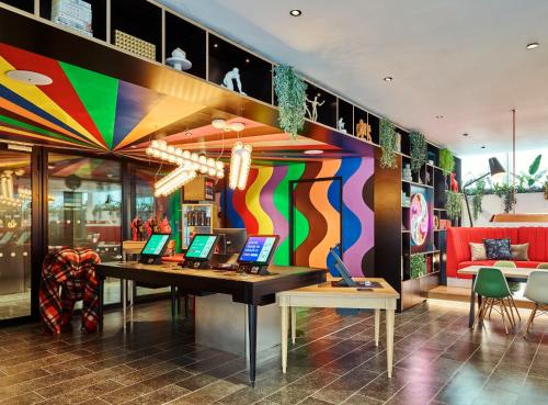 a room with a desk with laptops on it at citizenM London Victoria Station in London