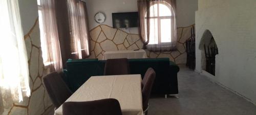 a room with a table and chairs and a room with a clock at Nemrut Güneş Motel in Yandere