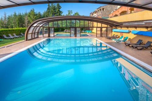 a swimming pool with a bridge over the water at Vilar Rural De Sant Hilari Sacalm by Serhs Hotels in Sant Hilari Sacalm