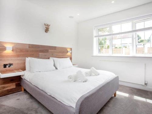 a bedroom with a large bed with two towels on it at HONEYBROOK - Cosey detached home, modern, spacious in Torquay