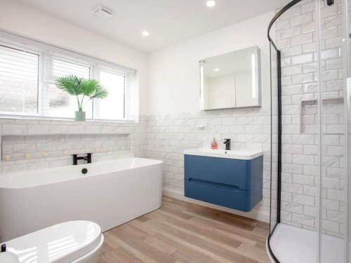 a bathroom with a tub and a sink and a toilet at HONEYBROOK - Cosey detached home, modern, spacious in Torquay