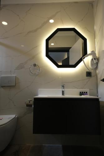 a bathroom with a sink and a mirror at The Pearl Airport Hotel in Arnavutköy
