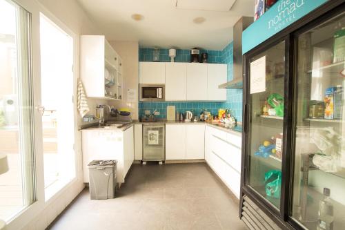 a kitchen with white cabinets and a refrigerator at The Nomad Hostel&Pension in Seville