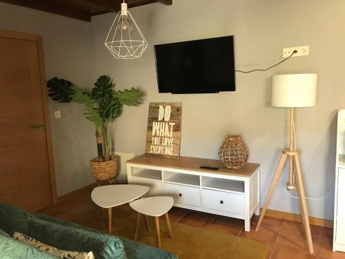 ein Wohnzimmer mit einem TV an der Wand in der Unterkunft Sosego in Sotomayor