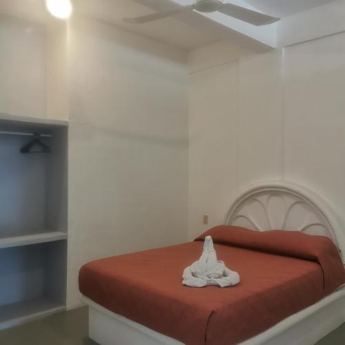 a bedroom with a bed with a red blanket at Large and comfy apartment, near DT and Principal Beach! in Zihuatanejo