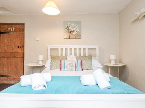 1 dormitorio con 1 cama grande y 2 mesas en Tinners Cottage, en Saint Cleer