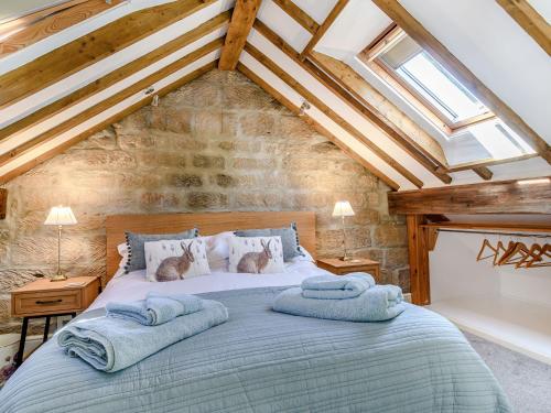1 dormitorio con 1 cama con 2 toallas en Cottage Anton, en Fylingdales