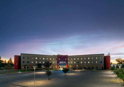 a large building with a parking lot in front of it at Park Inn by Radisson Polokwane in Polokwane