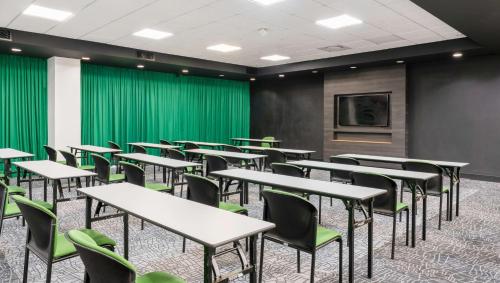 a room with tables and chairs and a tv at Park Inn by Radisson Polokwane in Polokwane