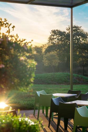 a patio with tables and chairs and a view of a field at Park Inn by Radisson Polokwane in Polokwane