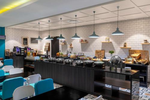 a restaurant with blue chairs and a counter with food at Park Inn by Radisson Polokwane in Polokwane