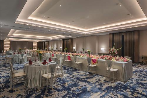 a banquet hall with tables and chairs and flowers at Radisson Blu Hotel & Spa, Nashik in Nashik