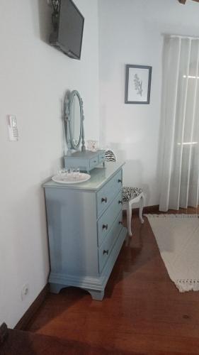 baño con tocador azul con espejo en Quintinha dos Amores, en Vila Verde