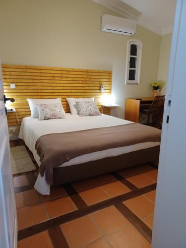 1 dormitorio con 1 cama grande y cabecero de madera en Quintinha dos Amores, en Vila Verde