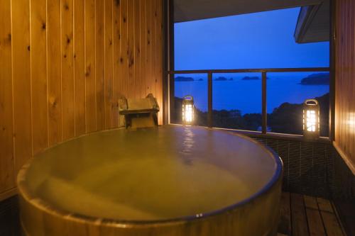 a large bath tub in a room with a window at Ryoso Uminocho in Ise