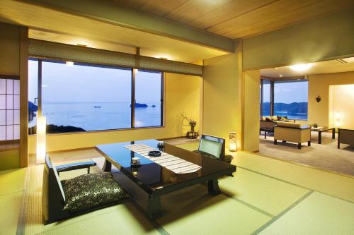 a living room with a table and a couch at Ryoso Uminocho in Ise