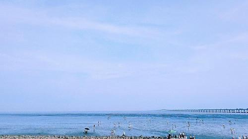 a group of people on a beach in the ocean at Holiday Inn Shanghai Dishui Lake by IHG in Nanhui