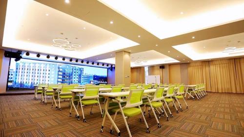 a conference room with tables and green chairs at Holiday Inn Shanghai Dishui Lake by IHG in Nanhui