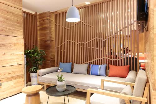 - un canapé dans une chambre dotée de murs en bois dans l'établissement Holiday Inn Express Jiuzhaigou, an IHG Hotel, à Jiuzhaigou