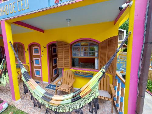 a play house with a hammock outside of it at Pousada Pedacinho de Céu in Abraão