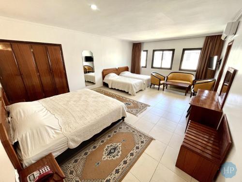 um quarto de hotel com uma cama e uma sala de estar em Hôtel Plaisance em Meknès