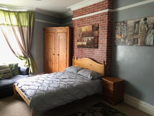 a bedroom with a bed and a brick wall at 6 Bedroom Villa in Barnsley Centre in Barnsley