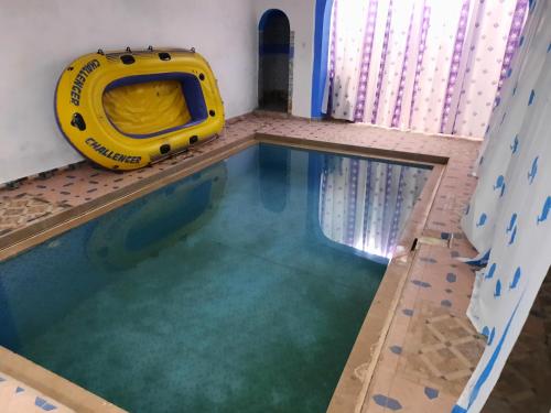 een binnenzwembad met een geel oogie-bord bij Dar Elbiad A1, duplex très mignon in Ifargane