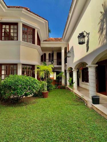 a large house with a green yard in front of it at Hotel Boutique Villas Segovia Cozumel in Cozumel