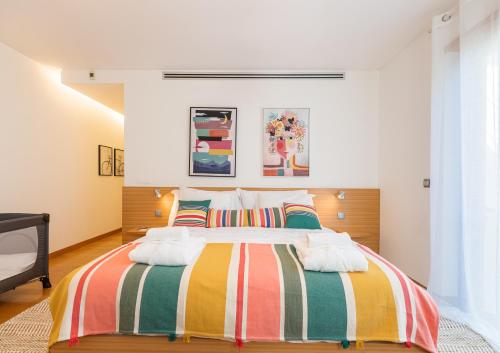 una camera da letto con un grande letto con coperte colorate di Algarve Vale Lobo Golf&Beach with Private Pool I a Vale do Lobo