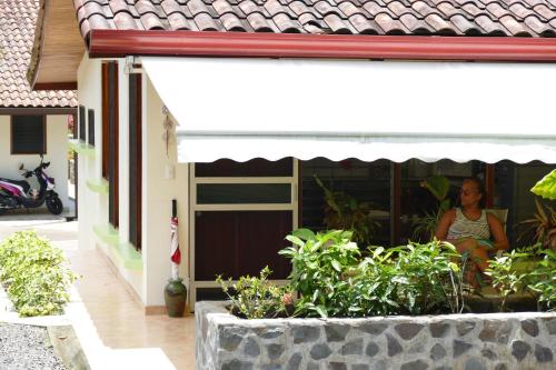 a woman sitting in a window of a house at Bungalows Sanlaz in Barrio Jesús