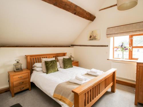 a bedroom with a large bed and a window at The Old Farmhouse in Craven Arms