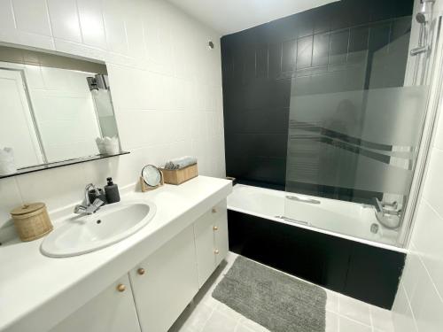 Baño blanco con lavabo y espejo en Quimper: T3 avec vue cathédrale proche gare, en Quimper