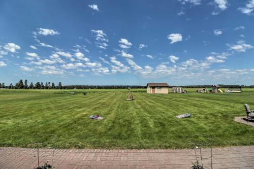 a large grassy field with a house in the distance at Columbia Falls Home with 1-Acre Yard and Views! in Columbia Falls