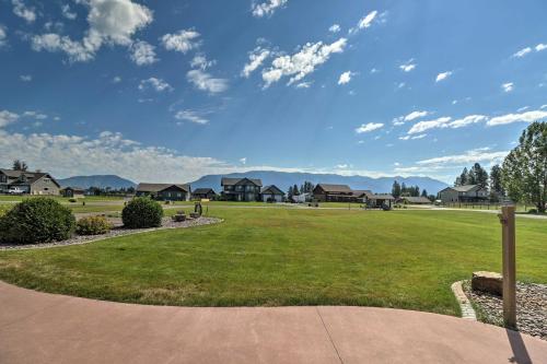 a grassy yard with houses in the background at Columbia Falls Home with 1-Acre Yard and Views! in Columbia Falls