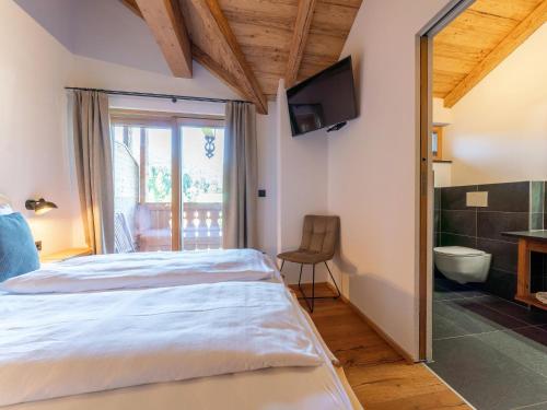 a bedroom with a bed and a bathroom with a television at AlmApARTment Mauterndorf Pichl 9-4 in Mauterndorf