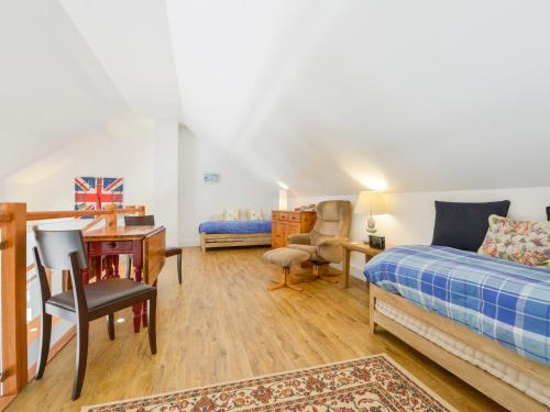 a bedroom with a bed and a desk and a chair at The Old Parlour in Sampford Courtenay