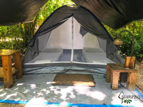 namiot z łóżkiem i stołem w obiekcie Guarumbo w mieście Bacalar