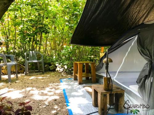 a tent with a table and chairs in a yard at Guarumbo in Bacalar