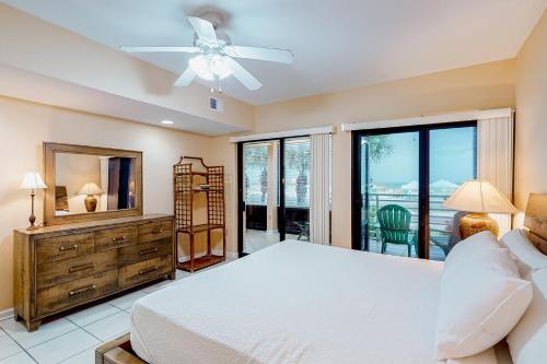 Un dormitorio con una cama y un ventilador de techo. en Palm Beach Club #126, en Pensacola Beach