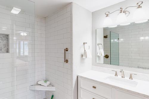 Un baño blanco con lavabo y espejo. en Palm Beach Club #126, en Pensacola Beach